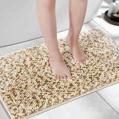 a person standing on a rug in the bathroom