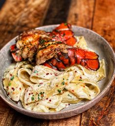 lobster and pasta in a bowl on a wooden table