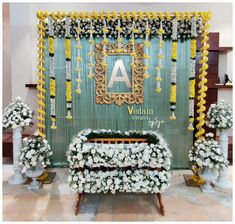 an arrangement of flowers on display in front of a wall with the letters a and v