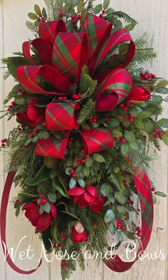 a red and green christmas wreath hanging on the side of a building