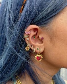 a woman with blue hair wearing ear piercings