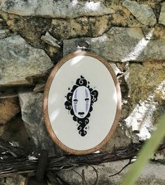 a cross stitch pattern with a woman's face in the center on a stone wall