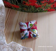 a red and white bow sitting on top of a piece of fabric next to a lace doily