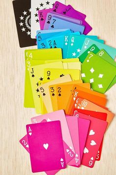 colorful playing cards with numbers and symbols on them sitting on a wooden surface, ready to be played