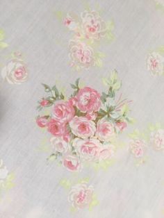 a flowered table cloth with pink roses on it