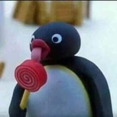 a penguin holding a lollipop in its mouth