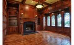 an empty living room with wood paneling and large windows