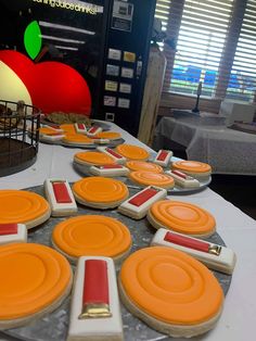 decorated cookies on a table with an apple in the background