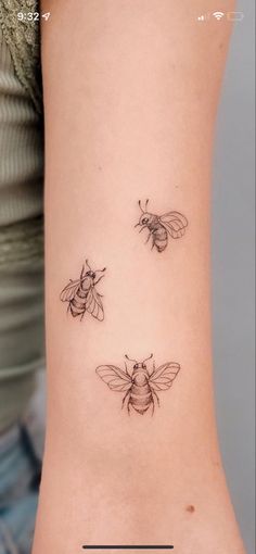 three bees on the back of a woman's left arm, one is black and white