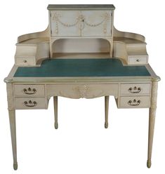 an antique desk with green top and drawers