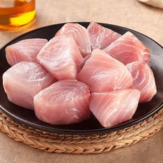 raw fish fillets in a black plate on a table