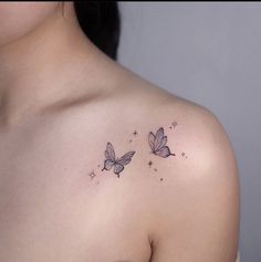 a woman's shoulder with two butterfly tattoos on the left side of her chest