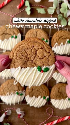 someone is holding up a chocolate chip cookie with white frosting and candy canes