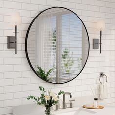 a bathroom sink with a mirror above it and flowers in the vase on the counter