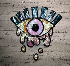 a brooch with an evil eye on it's face and words in the background