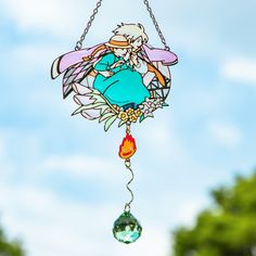 a stained glass wind chime hanging from a chain with an angel on it's back