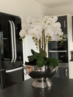 white flowers in a silver bowl on a kitchen counter