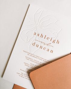 the wedding stationery is laid out on top of each other, including an envelope