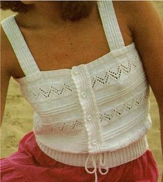 a close up of a person wearing a white top and red shorts with a cell phone