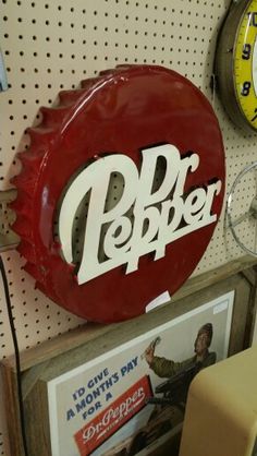 there is a red sign that says dr pepper on the wall next to two clocks