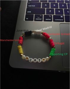 a bracelet with the word cr7 on it sitting in front of a laptop computer