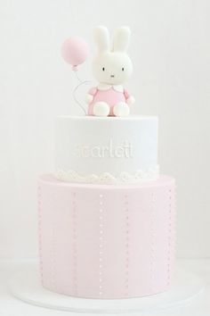 a pink and white cake with a bunny on top