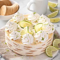 a cake sitting on top of a white plate covered in frosting and limes