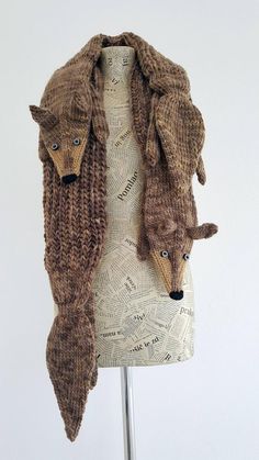 a knitted scarf with two foxes on it's head and one in the shape of a coat