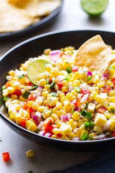 corn salad with tortilla chips in a black bowl