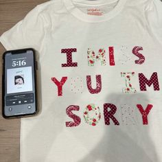 a cell phone sitting next to a t - shirt that says, this is your story