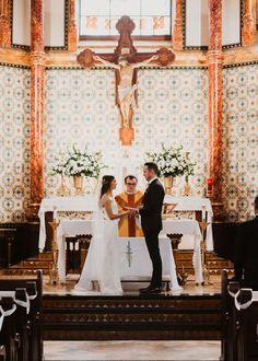 a bride and groom standing at the alter during their wedding ceremony