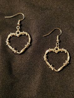 Barbed wire heart charms on earring hooks.  Silver tone, set of two earrings.  Handmade and ready to ship, each measures about 1.75 inches long, 1 inch wide. To continue shopping: http://www.rrrobinnn.etsy.com Gothic Wire Jewelry, Goth Wire Jewelry, Silver Grunge Jewelry For Valentine's Day, Grunge Style Heart-shaped Metal Jewelry, Punk Heart-shaped Pierced Earrings, Nickel-free Metal Grunge Earrings, Punk Heart-shaped Earrings, Nickel-free Metal Earrings In Grunge Style, Grunge Metal Earrings Nickel Free