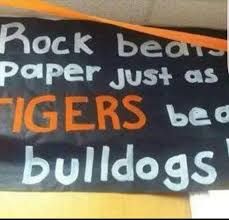 a sign that says rock beats, paper just as tigers beat bulldogs on it