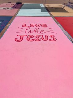 a pink painted walkway with the words love like jesus written on it in red ink