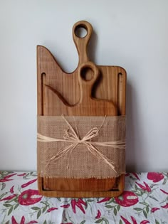 a cutting board with a wooden handle tied up to it