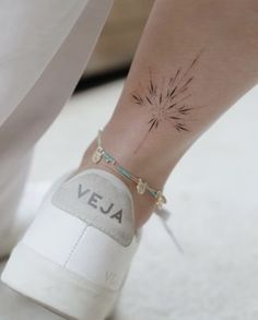 a woman's foot with a flower tattoo on her left ankle and the word vera written in black ink