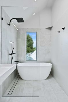 a large white bath tub sitting next to a window