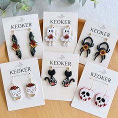 six pairs of earrings are on display in front of a card that says keoker