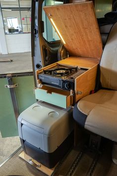 the interior of a van with an open trunk on it's back end and two stools in front