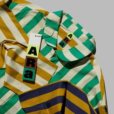 a shirt that has the word arra on it and is yellow, green, blue and white stripes