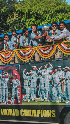 a tour bus filled with men standing on top of it's sides and holding trophies