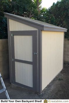 a small storage shed with the door open on a backyard side walk in front of a fence