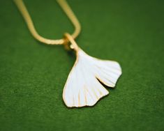 The ginkgo tree, a sacred tree of the East, is thought to be one of the oldest living trees, dating back to more than 200 million years. In Japanese decorative art, the ginkgo’s distinctive fan-shaped leaf has been a symbol of longevity, profound endurance and unity of opposites.The Japanese Gingko Leaf series from the Shinji Classic Collection radiates timeless elegance. The Gingko Leaf series has been created with the gold and silver layering technique synonymous to the Shinji Classic collecti White Leaf-shaped Jewelry Gift, Japanese Pendant, Necklace Japanese, Ginkgo Tree, Japanese Jewelry, Gingko Leaves, Sacred Tree, Casual Rings, Casual Earrings