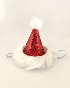 "Mini Christmas Santa Hat  2.5\" diameter x 3\" tall  Made from non-shedding Glitter  Adorned with silver tinsel garland and mini Pom ornaments Medium Christmas Santa  Hat  5.25\" tall x 3.5 diameter  Limited Quantity available  Perfect for pets or humans  Made with an elastic band  Please leave a note at checkout if this is for a human or pet and if pet small, medium or large breed." Adjustable Mini Hats For Christmas Party, Red Novelty Mini Hats For Party, Red Novelty Mini Hats For Parties, Novelty Red Mini Hats For Party, Adjustable Christmas Party Hats, Mini Santa Hat, First Birthday Hat, First Birthday Hats, Mini Pom