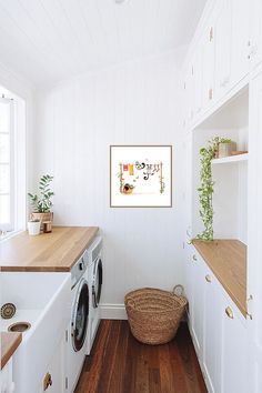 a washer and dryer in a white laundry room with wood flooring on the side