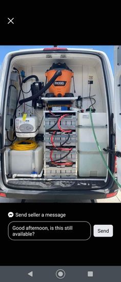 the back end of a van with an open trunk filled with electronics and other items