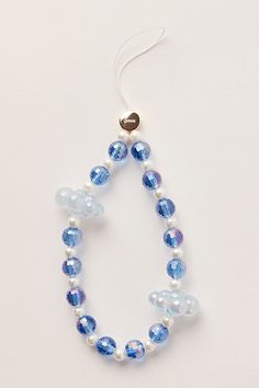 a necklace with blue and white beads hanging from it's side on a white surface