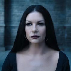 a woman with long black hair and dark lipstick