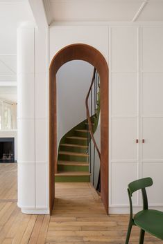 a green chair sitting in front of a wooden staircase