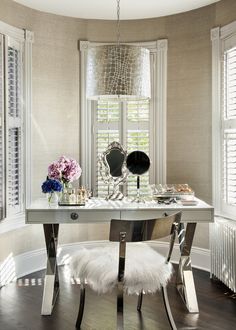 a room with a table, mirror and flowers in vases on the table next to it